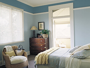 Blue bedroom with dark furniture